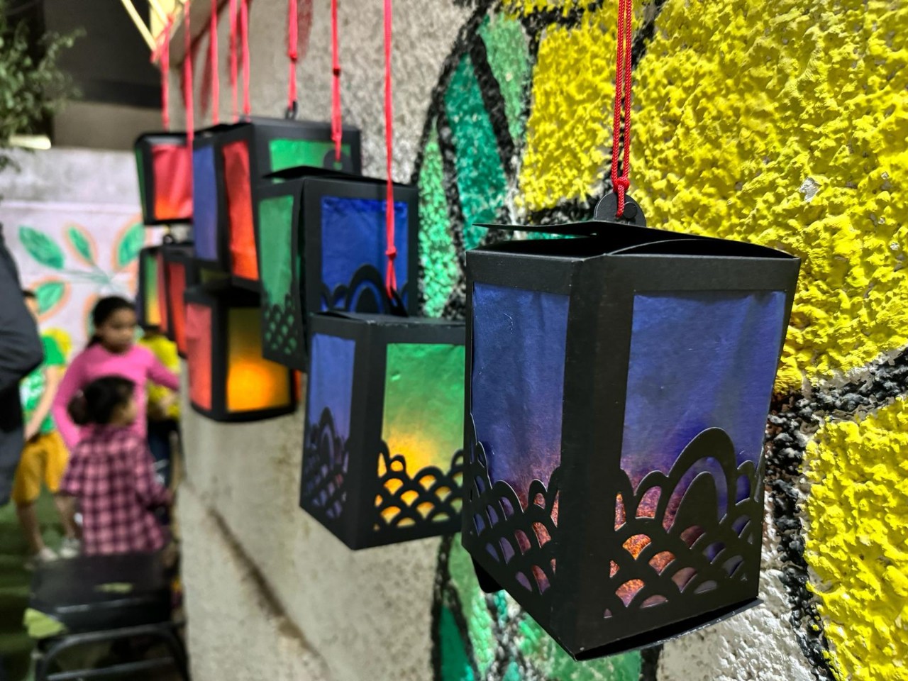 A group of colorful lanterns on a wall

Description automatically generated
